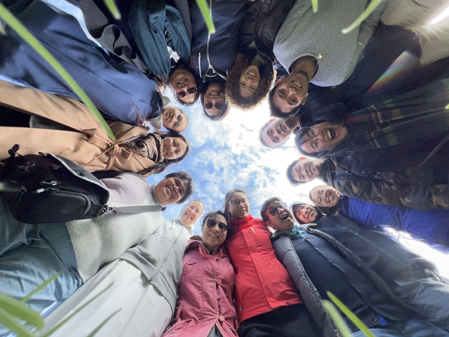 Young adults gathered in a circle looking up, symbolizing community